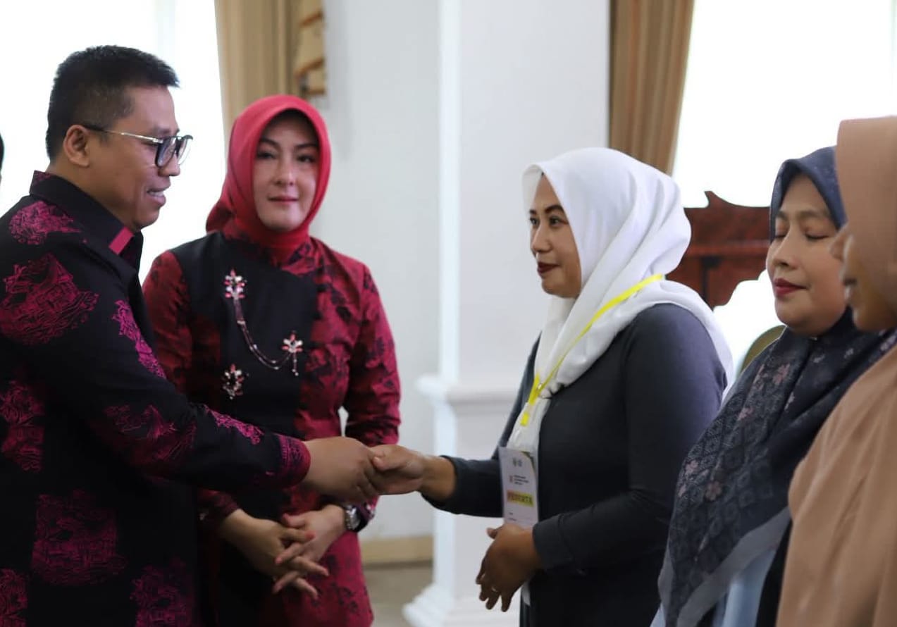 Wako Hendri didampingi Ketua TP PKK Maria Feronica Hendri, saat menyalami peserta sekolah keluarga